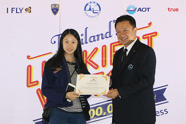 Ms. Huang Junyi receives a certificate naming her as Thailands Luckiest Visitor  The Amazing, Smashing Success from Mr. Yuthsak Supasorn, TAT Governor