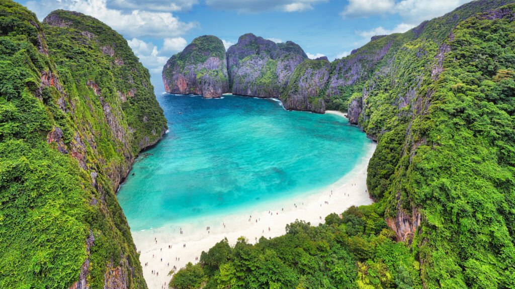 Iconic Maya Bay at Phi Phi Le with emerald waters and white sandy beach framed by dramatic limestone cliffs in Krabi.