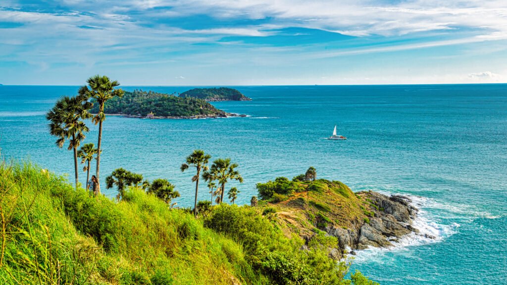 Scenic viewpoint at Promthep Cape, Phuket, overlooking turquoise seas and nearby islands under a bright tropical sky.